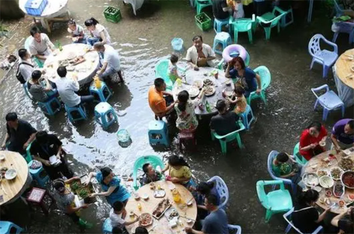 河南暴雨 宾客坐积水中吃席 宾客在暴雨中吃席