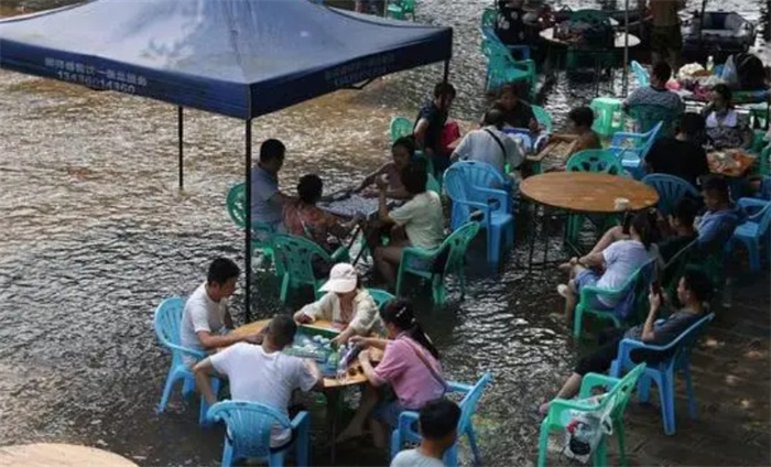 河南暴雨 宾客坐积水中吃席 宾客在暴雨中吃席
